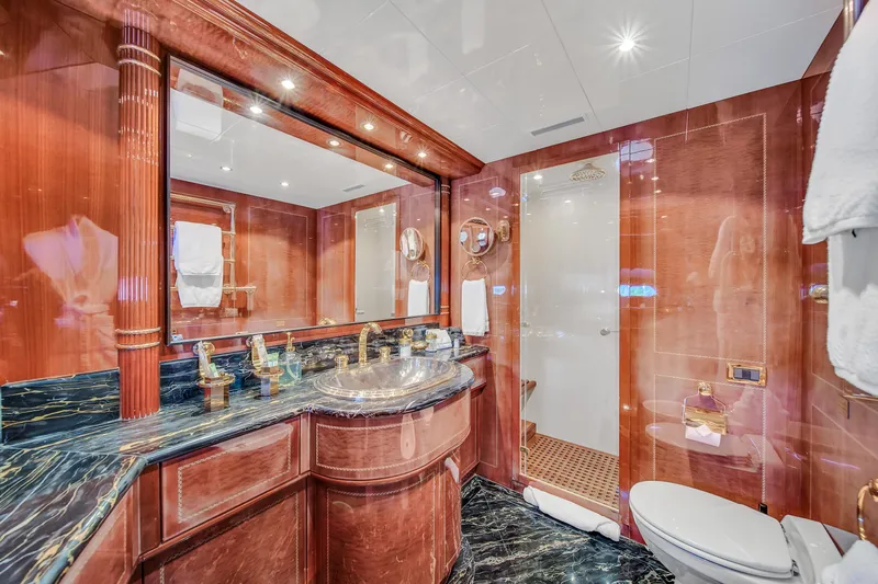  Yacht Photos Pics Luxurious bathroom in 2002 Mangusta 108 yacht with marble countertops and elegant wood finishes.