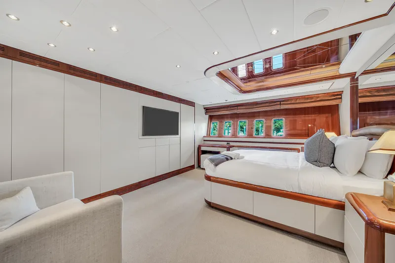  Yacht Photos Pics Luxurious bedroom interior of 2002 Mangusta 108 yacht with elegant wood accents and modern design.