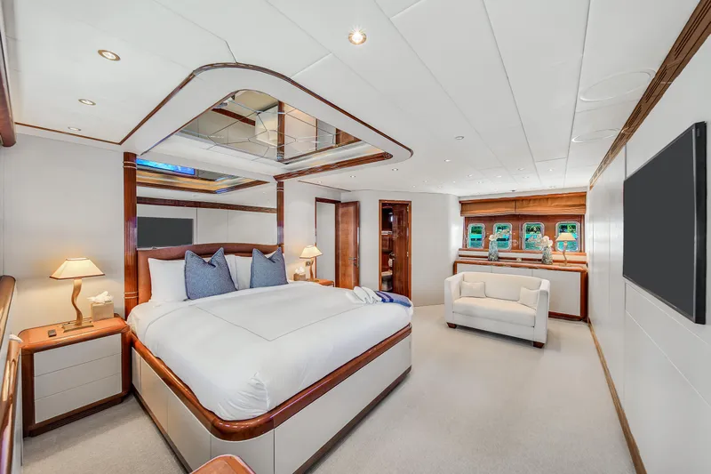  Yacht Photos Pics Luxurious bedroom interior on 2002 Mangusta 108 yacht, featuring elegant furnishings and modern design.