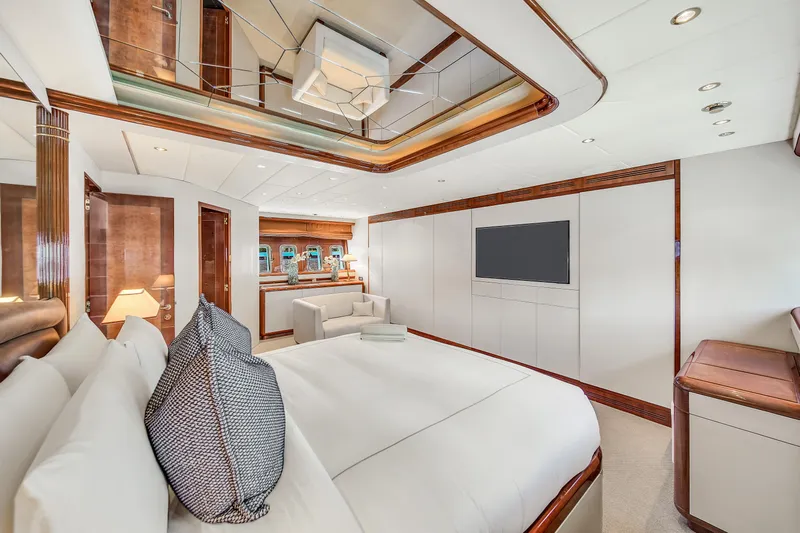  Yacht Photos Pics Luxurious bedroom interior of 2002 Mangusta 108 yacht with modern decor and elegant furnishings.