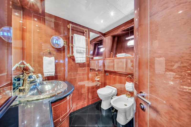  Yacht Photos Pics Luxurious bathroom in 2002 Mangusta 108 yacht with elegant wood paneling and modern fixtures.