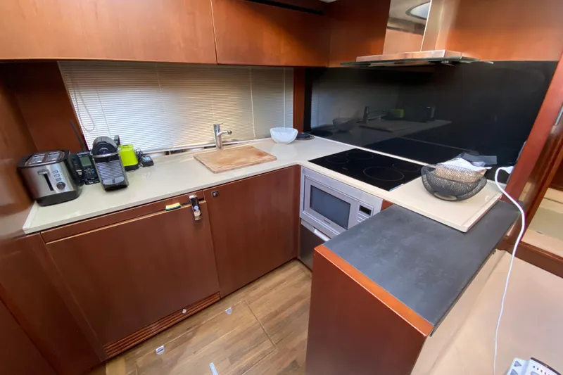 Aum Yacht Photos Pics Modern kitchen interior on a 2013 Princess V57 yacht, featuring sleek appliances and wooden cabinetry.