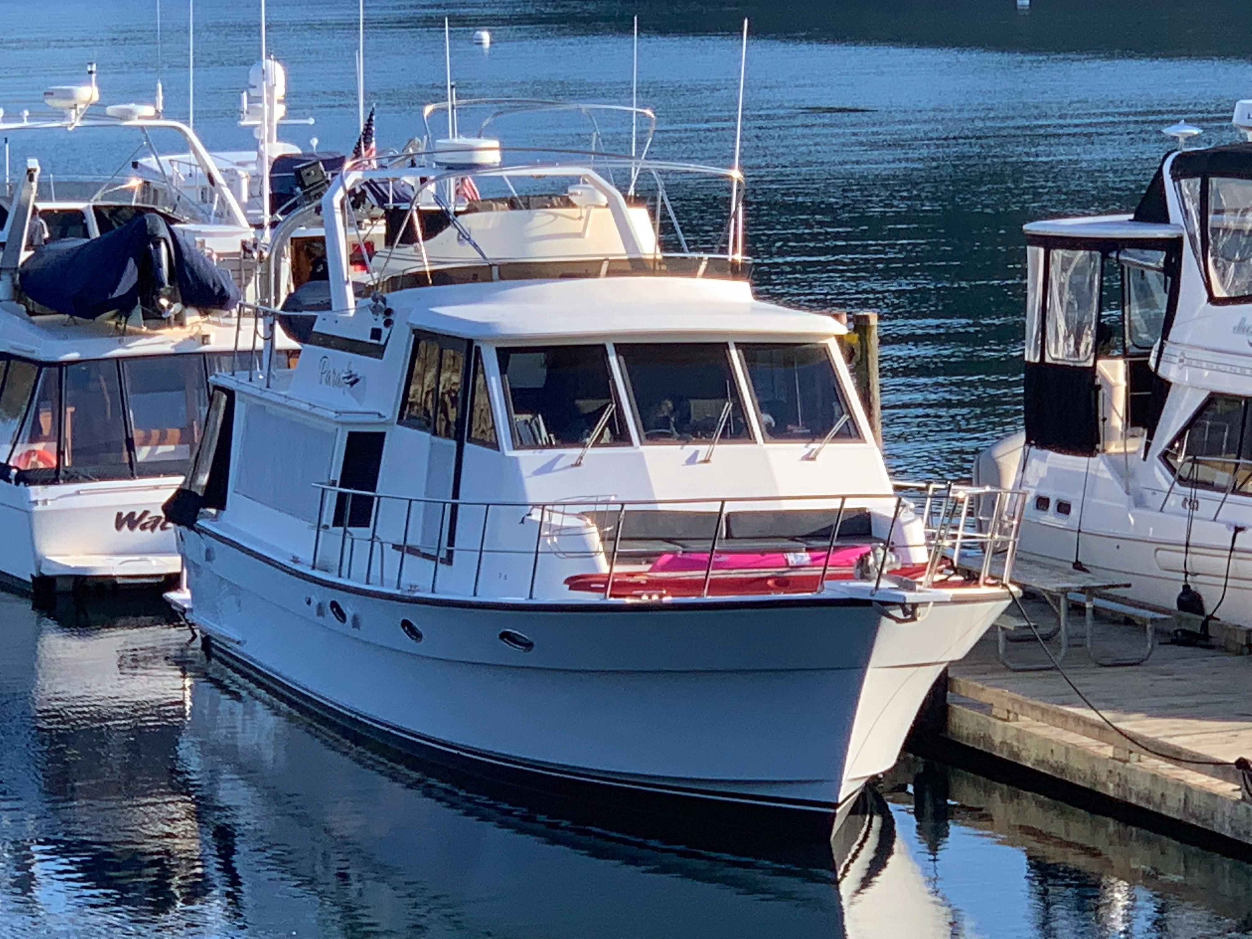A 1990 Nova 4500 yacht docked at a marina, surrounded by other boats.