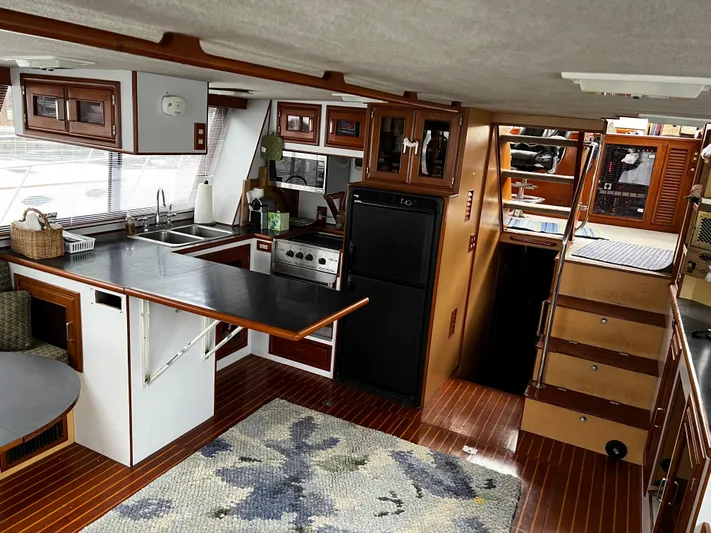 Paradosi Yacht Photos Pics Interior of a 1990 Nova 4500 boat, featuring a kitchen and wooden flooring.