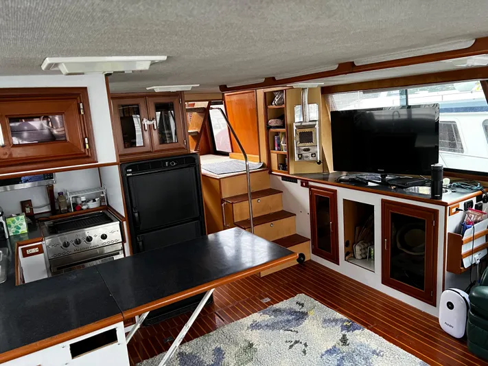 Paradosi Yacht Photos Pics Interior of a 1990 Nova 4500 boat with kitchen, dining area, and entertainment setup.