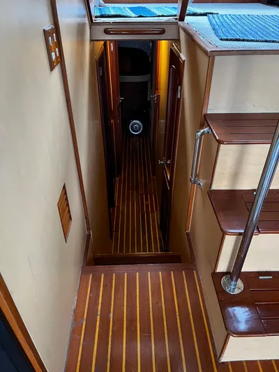 Paradosi Yacht Photos Pics Interior of a 1990 Nova 4500 boat with wooden stairs and hallway.