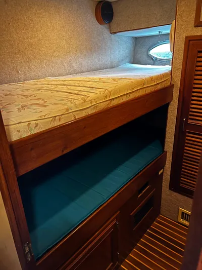 Paradosi Yacht Photos Pics Bunk beds in a 1990 Nova 4500 RV, featuring wood paneling and cozy bedding.