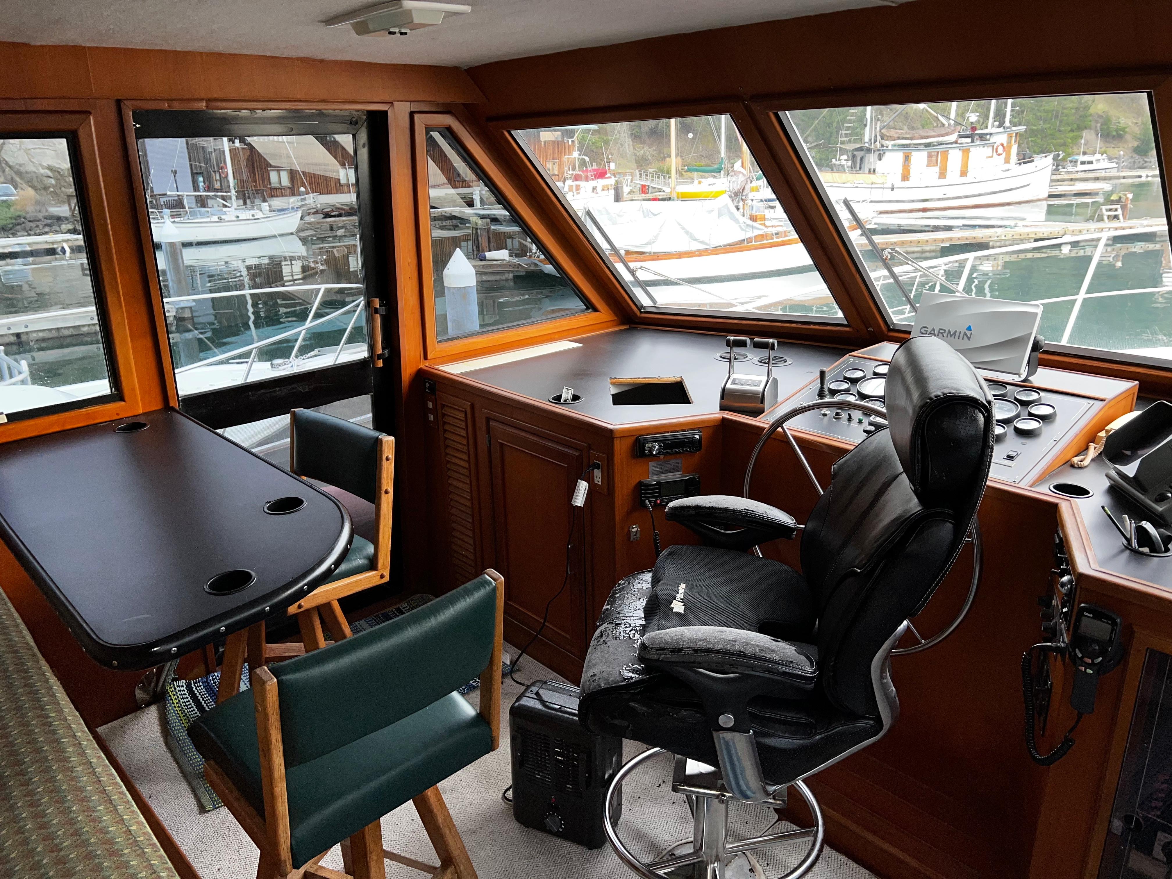 Interior of a 1990 Nova 4500 boat with helm, seating, and marina view.