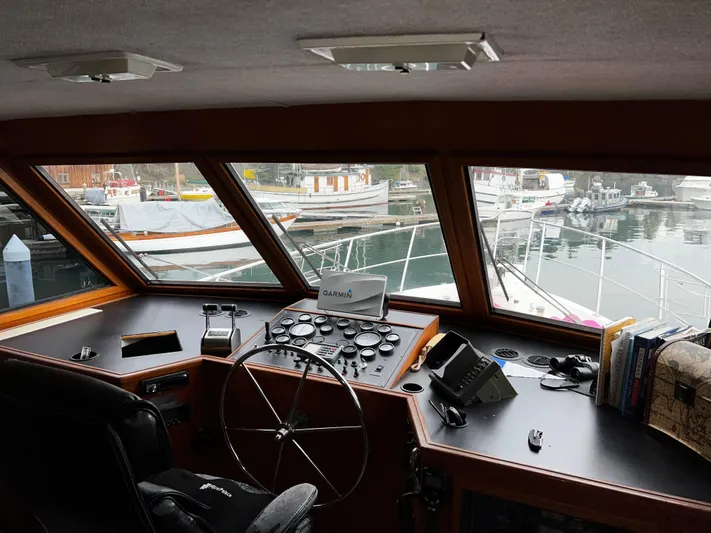 Paradosi Yacht Photos Pics Interior view of a 1990 Nova 4500 boat cockpit with marina in background.