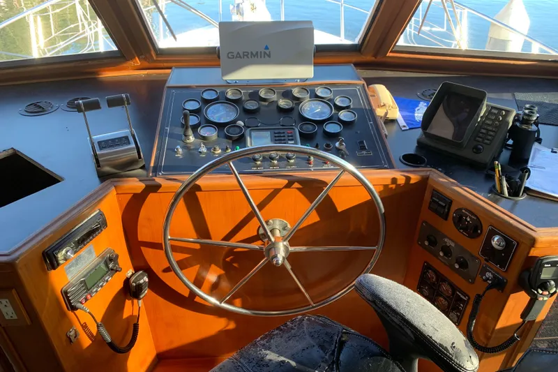 Paradosi Yacht Photos Pics Cockpit of a 1990 Nova 4500 boat with steering wheel and navigation instruments.