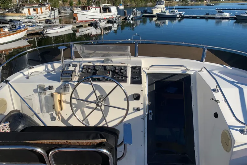 Paradosi Yacht Photos Pics Helm of 1990 Nova 4500 boat with steering wheel, docked at marina.