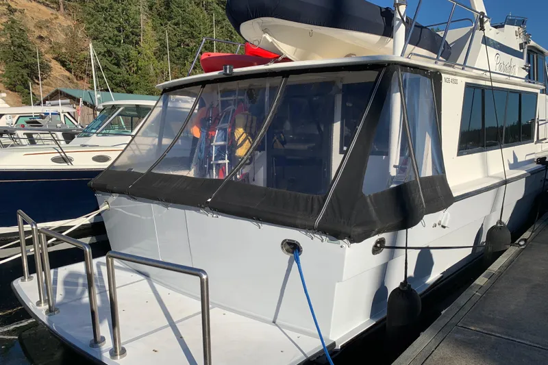 Paradosi Yacht Photos Pics 1990 Nova 4500 boat docked, featuring a covered rear deck and visible marina background.