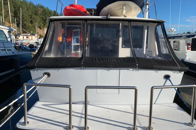 Paradosi Yacht Photos Pics 1990 Nova 4500 boat docked, rear view with canopy and railing, clear sky background.