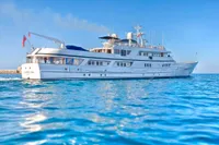Luxurious 1982 custom yacht by Husumer Shipyard on clear blue water.