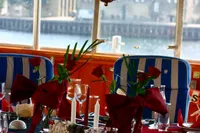 Elegant dining setup on a 1982 Custom Husumer Shipyard vessel, featuring red accents and nautical decor.
