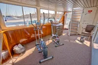 Gym area on a 1982 Custom Husumer Shipyard yacht with exercise bikes and scenic views.