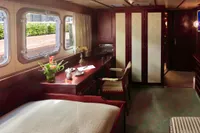 Luxurious ship cabin interior with wooden furniture, desk, and large windows, Husumer Shipyard 1982 model.