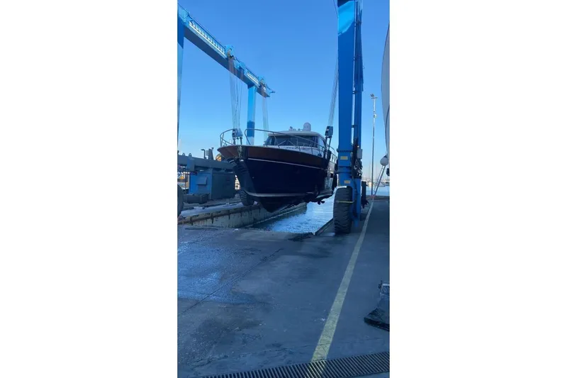 Yacht Photos Pics 2007 Apreamare 48 yacht being lifted at a shipyard with blue sky background.