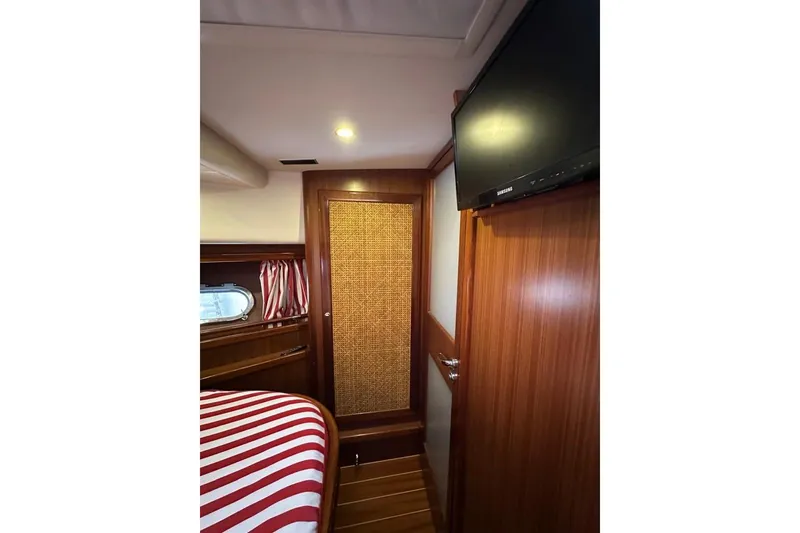  Yacht Photos Pics Interior of 2007 Apreamare 48 yacht with wood paneling and striped bedding.