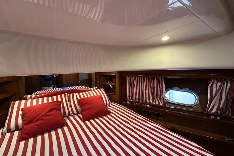  Yacht Photos Pics Luxurious cabin interior of 2007 Apreamare 48 yacht with striped bedding and porthole.