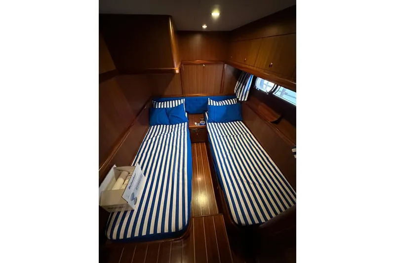  Yacht Photos Pics Cabin interior of 2007 Apreamare 48 yacht with striped bedding and wooden finish.