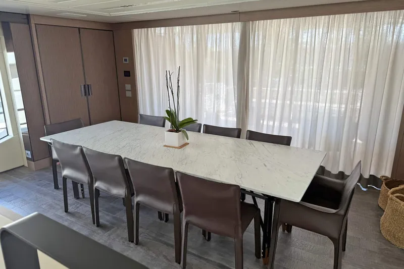 Ship Happens Yacht Photos Pics Luxurious dining area on 2024 Maiora 30 Walkaround yacht with marble table and elegant chairs.