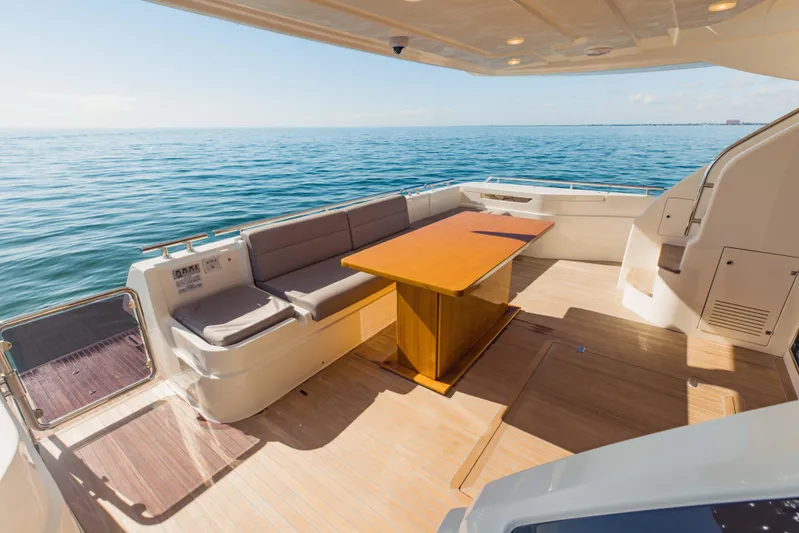 Sami Kay III Yacht Photos Pics Luxurious 2017 Ferretti Yachts 750 deck with seating and table, overlooking serene ocean waters.