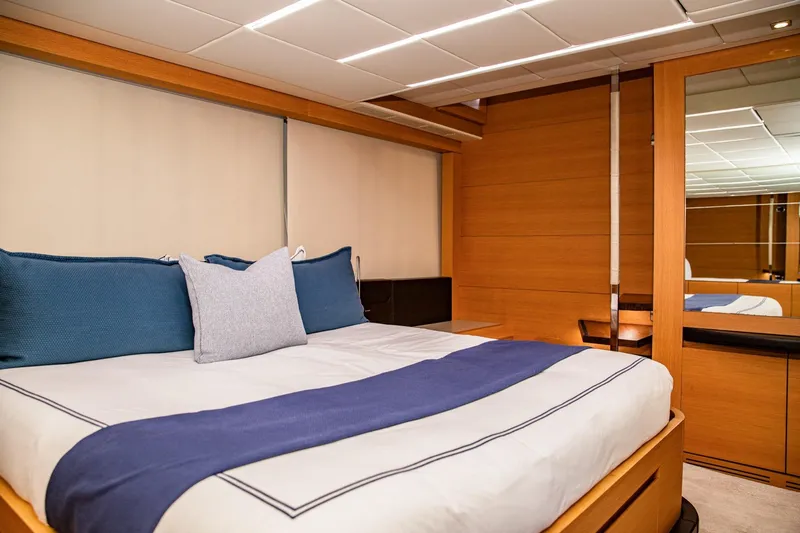 Dorothy Ann Yacht Photos Pics Luxurious bedroom interior of 2012 Pershing Sport Boat Planning, featuring elegant wood paneling.