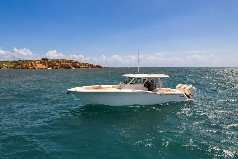  Yacht Photos Pics 2024 Scout 377 LXF boat cruising on open water under clear blue sky.