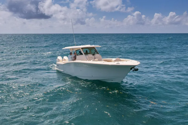 Yacht Photos Pics 2024 Scout 377 LXF boat cruising on open ocean under cloudy sky.