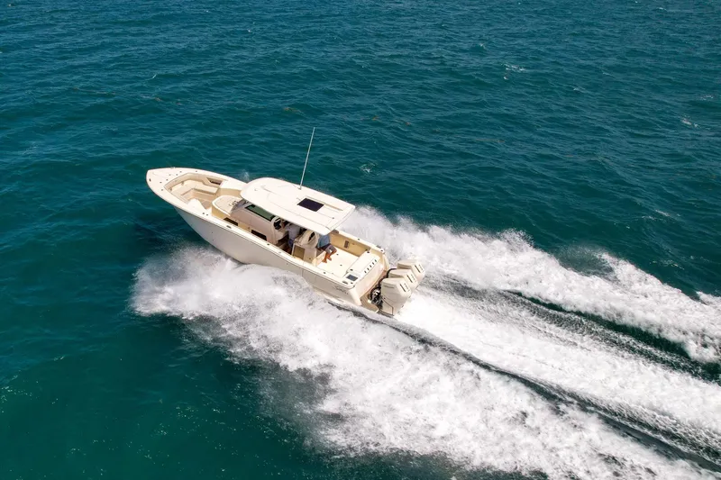  Yacht Photos Pics 2024 Scout 377 LXF boat cruising on open water, creating a dynamic wake.