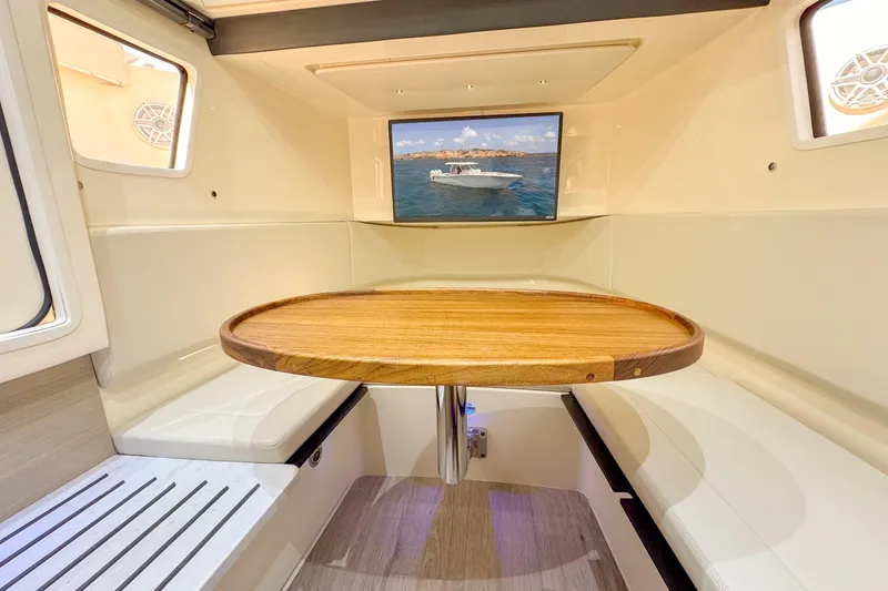  Yacht Photos Pics 2024 Scout 377 LXF interior with wooden table and cushioned seating.