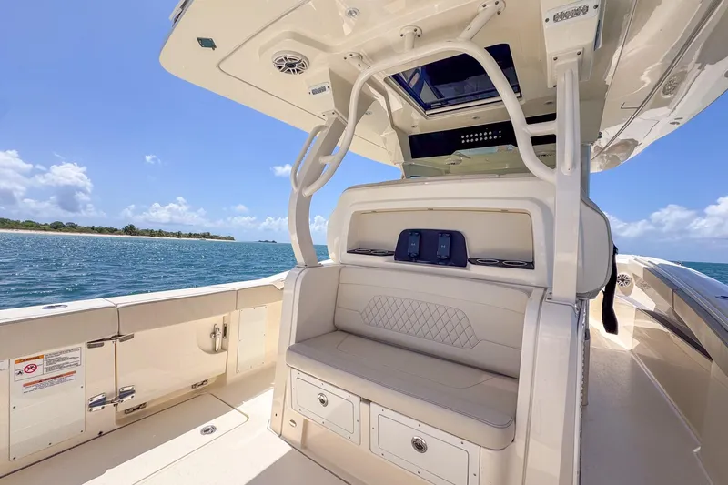  Yacht Photos Pics 2024 Scout 377 LXF boat interior with seating, ocean view, and clear sky.