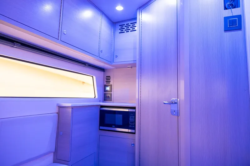  Yacht Photos Pics 2024 Scout 377 LXF interior with modern cabinetry and microwave, illuminated in blue lighting.