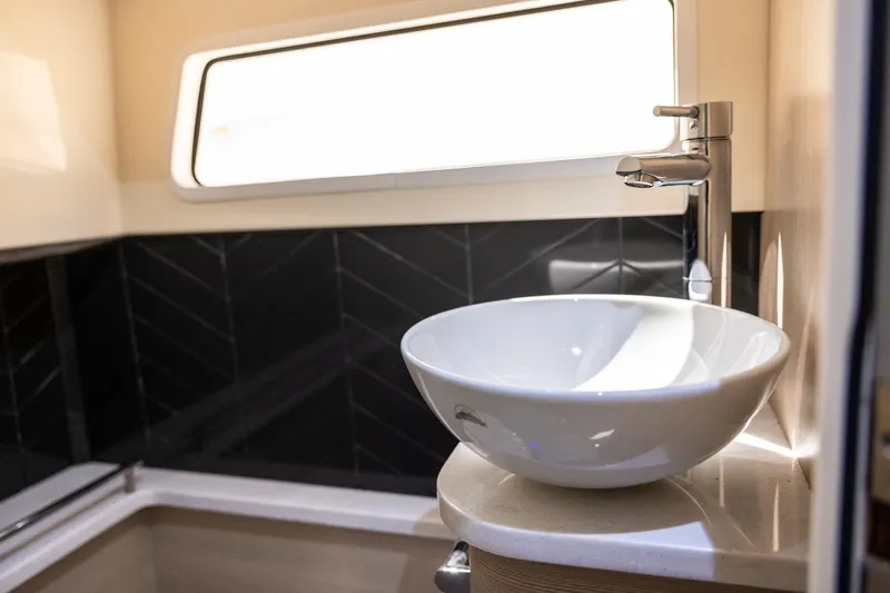  Yacht Photos Pics 2024 Scout 377 LXF bathroom with modern sink and sleek black tile design.