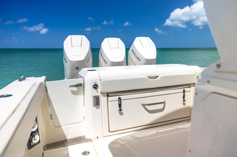  Yacht Photos Pics 2024 Scout 377 LXF boat with triple Mercury engines on a sunny ocean backdrop.