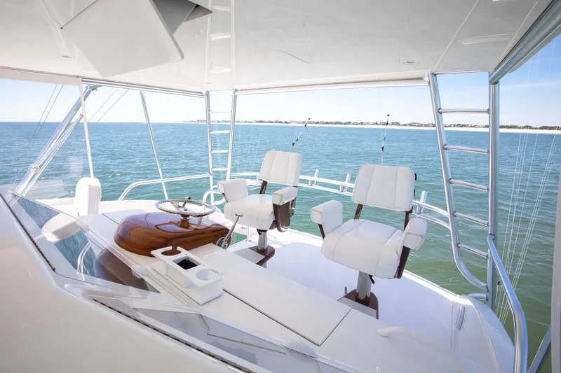 Warden Pass Yacht Photos Pics 2010 Viking 57 Sportfish yacht helm with ocean view, featuring two white captain chairs.