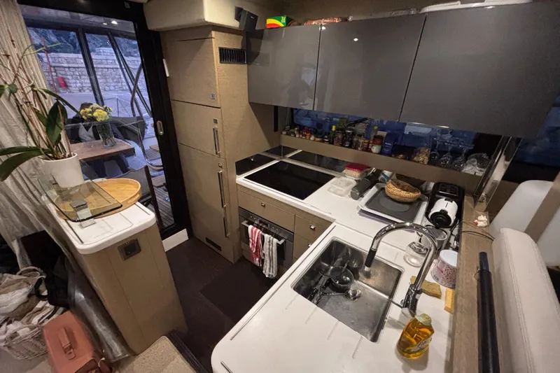  Yacht Photos Pics Modern kitchen interior on a 2018 Prestige 560 yacht, featuring sleek cabinetry and appliances.