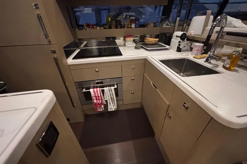  Yacht Photos Pics Modern kitchen interior on a 2018 Prestige 560 yacht, featuring sleek cabinetry and appliances.