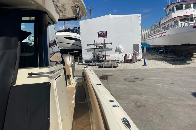  Yacht Photos Pics 2020 Chris-Craft Catalina 30 in a boatyard, surrounded by other vessels and equipment.
