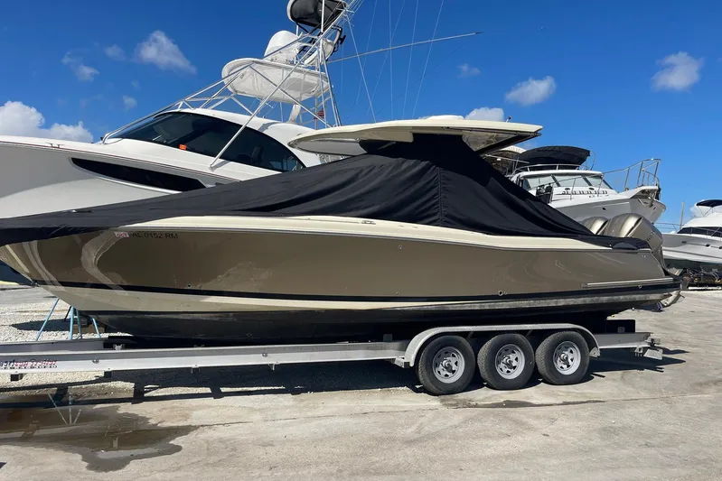  Yacht Photos Pics 2020 Chris-Craft Catalina 30 boat on trailer, covered, with other boats in background.
