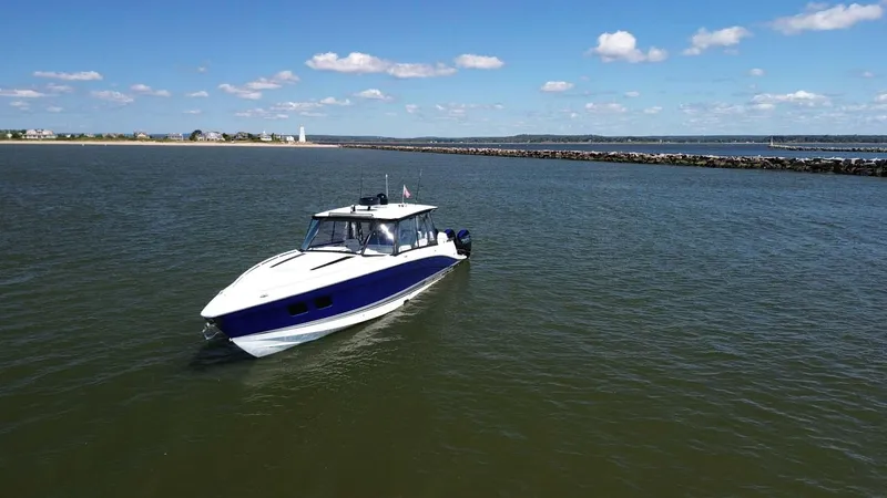 Blueprint Yacht Photos Pics 2020 Concept 44' Cuddy Cabin boat cruising on calm waters under a clear blue sky.