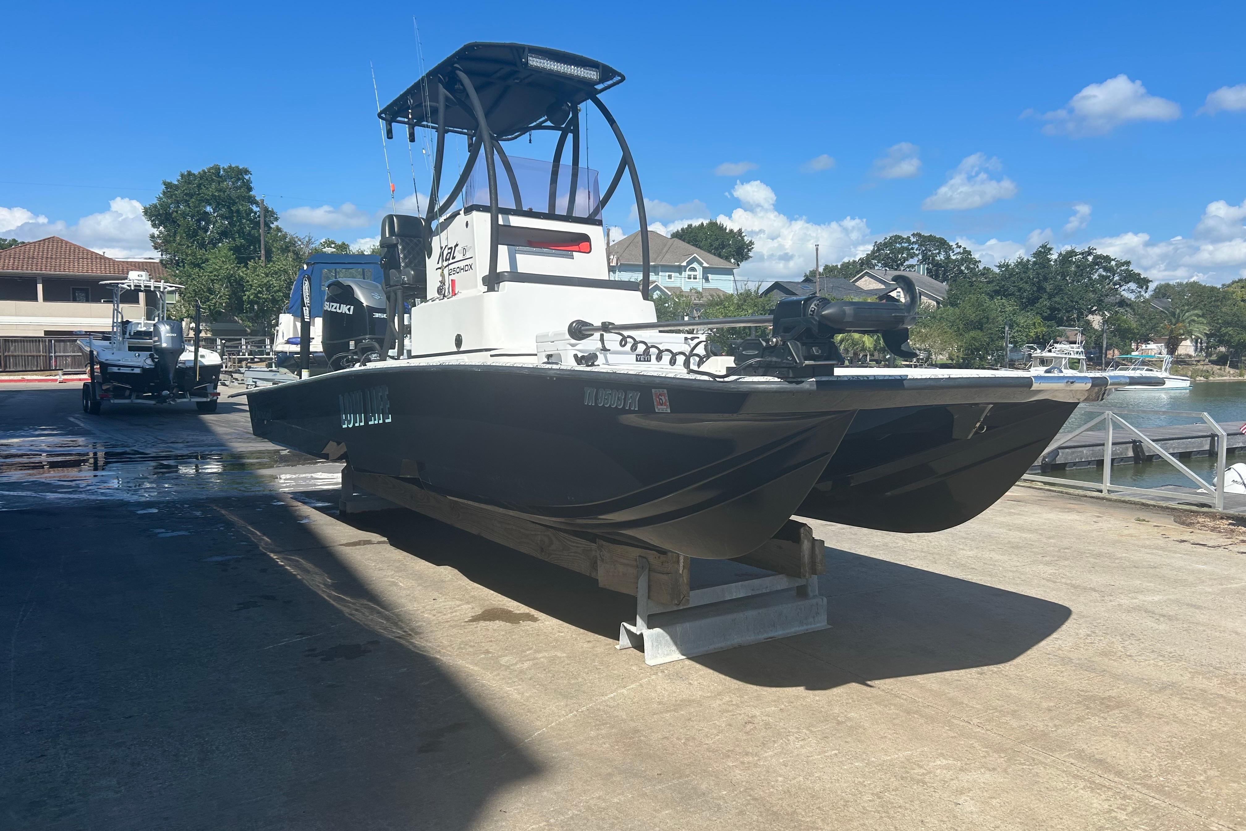 2020 Dargel Kat 250 HDX boat on trailer at marina under blue sky.