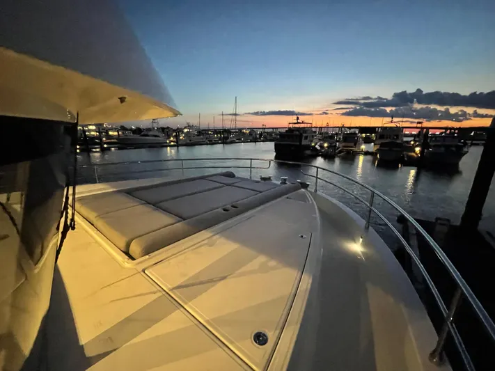  Yacht Photos Pics 2024 Beneteau Grand Trawler 62 at sunset, docked in a marina.