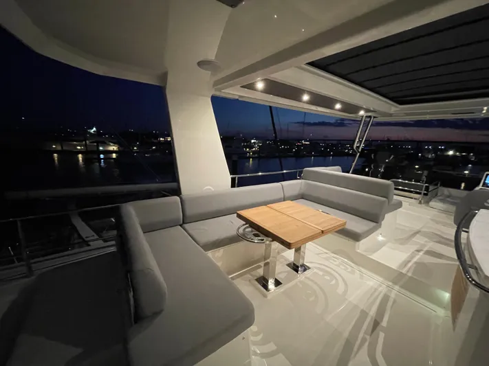  Yacht Photos Pics Luxurious 2024 Beneteau Grand Trawler 62 yacht deck at sunset, featuring elegant seating.