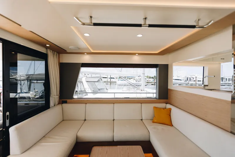  Yacht Photos Pics Luxurious interior of 2024 Beneteau Grand Trawler 62 with elegant seating and marina view.