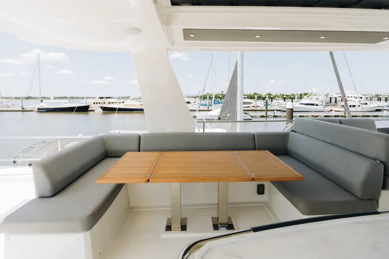  Yacht Photos Pics Luxurious seating area on 2024 Beneteau Grand Trawler 62 yacht, overlooking marina.