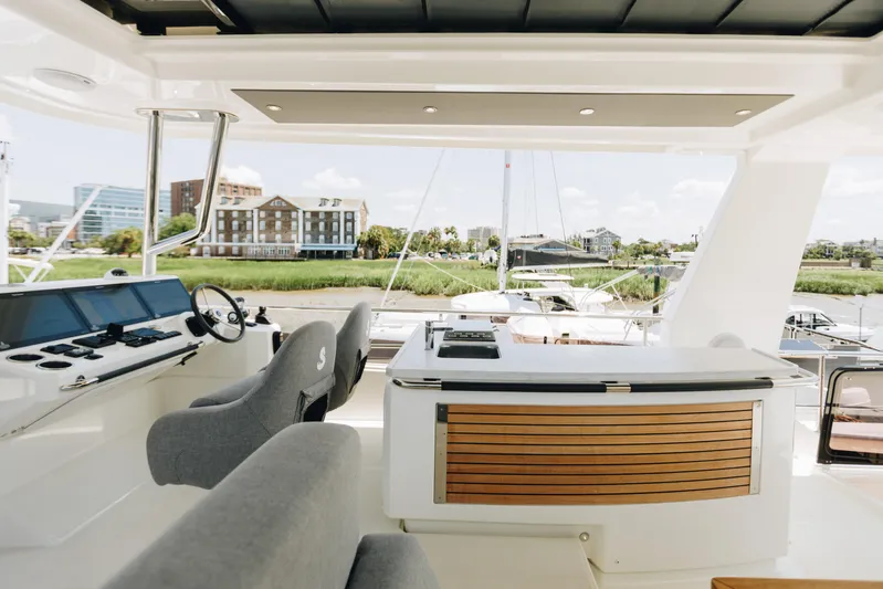  Yacht Photos Pics 2024 Beneteau Grand Trawler 62 helm and deck area with modern design and waterfront view.