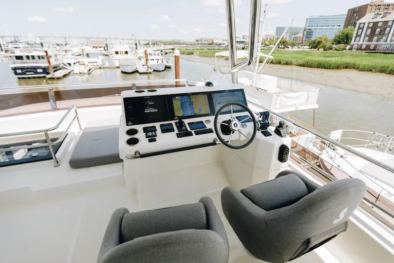  Yacht Photos Pics 2024 Beneteau Grand Trawler 62 helm station with modern controls and dual seats.