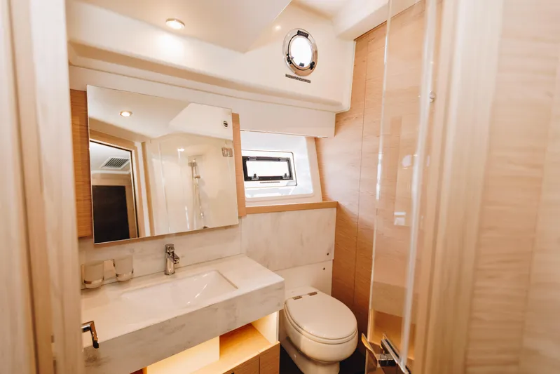  Yacht Photos Pics Luxurious bathroom in 2024 Beneteau Grand Trawler 62 yacht, featuring modern fixtures and elegant design.